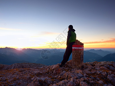 累徒徒徒步者坐在阿尔卑斯山的边界石上 奥地利德国边境薄雾岩石风景国界峡谷碎石远足者高山金字塔反转图片