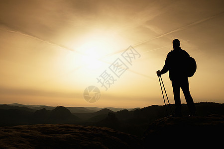 高高背背心徒步 手边有电杆薄雾风衣顶峰岩石登山者小路指导远足者伙伴旅游图片