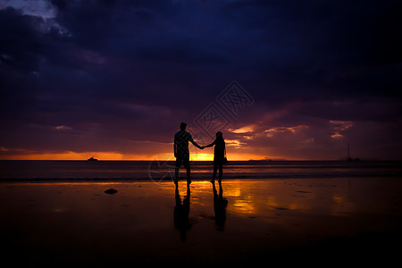 一对夫妇的休丽花 牵起彼此的手 欢乐的年轻情侣 在日落时在沙滩上相爱家庭太阳蜜月阳光夫妻海洋情人天空男人女性图片