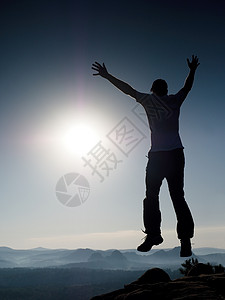 年轻的疯子正在跳上摇滚 跳人幻影环男性力量太阳天空上帝自由运动装精神信仰幸福图片