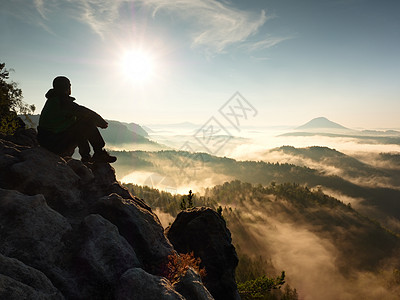 山顶上休息 山顶上躺着 秋天山谷下方悬崖危险活动岩石顶峰地形运动装迷雾成人薄雾图片