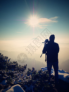 摄影师拍摄秋天风景冰冻的照片相片运动员三脚架日落砂岩太阳游客雪峰镜子阴影图片
