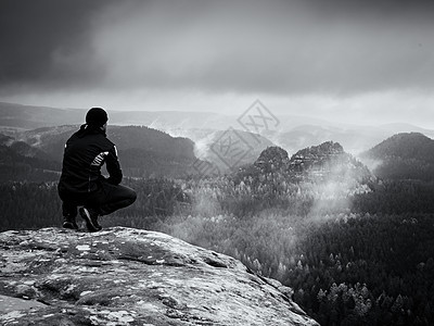 黑衣人坐在破碎的岩石帝国上 忧郁不安的日子图片