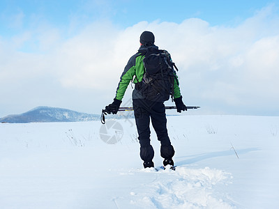 有雪鞋的男人在雪中休息 爬雪鞋运动男士阴影装备远足爬坡雪裤漂移成年人跨步图片