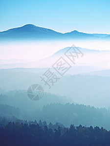 环绕大山丘的景色 美丽美丽的美景太阳阴影树梢天空薄雾游客边缘岩石爬坡童话图片