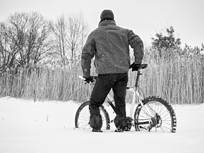 骑着山地自行车的运动员在雪中失落 野外冬天车轮框架辐条运动踏板森林竞赛天气变速器远足者图片