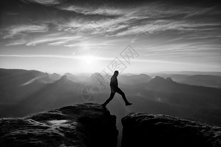 疯狂的徒步旅行者跳跃 在岩石山上美好的黎明快感反射乐趣保险速度砂岩晴天日出阴影薄雾图片
