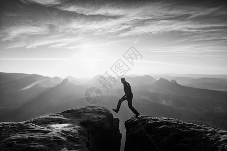 疯狂的徒步旅行者跳跃 在岩石山上美好的黎明远足顶峰阴影幸福晴天速度天气砂岩远足者快感图片