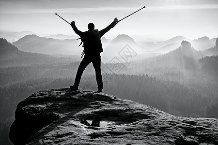 头顶有药杖的旅游者登上了山峰 而他却在山顶上爬了起来拐杖男性健康装备力量登山者背包伤害保险幸福冒险图片
