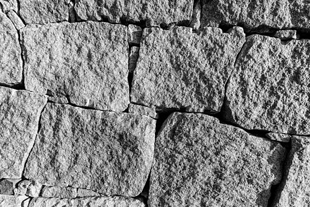 旧石砖墙的单色背景建造黑色圆形建筑材料建筑学白色灰色花岗岩岩石图片