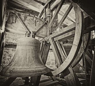 教堂塔里的老钟声车轮绳索黄铜历史钟楼滑轮黑与白背景图片