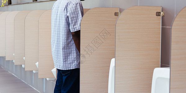 男子在男性厕所小便里尿尿图片