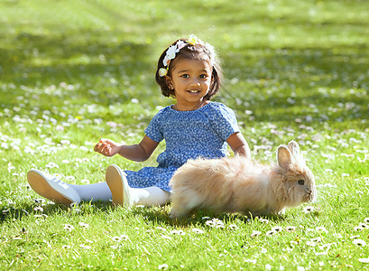 一个小亚洲女孩 家里养着青草的兔子图片