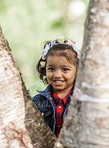 一个微笑的小女孩在公园里玩图片