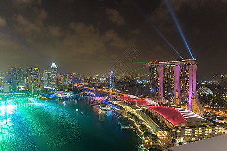 新加坡 — CIRCA 2020 滨海湾的天际线 艺术博物馆 著名酒店和新加坡摩天观景轮的夜景 背景是暴风雨的天空 除夕前有激光图片