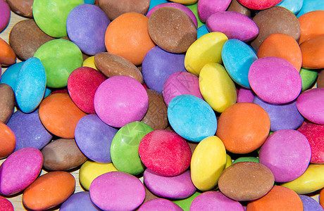 各种颜色的加糖糖果巧克力红色绿色涂层粉色黄色聪明人背景图片