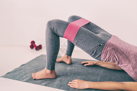 对大腿和臀部骨架绑架进行耐体家庭抗力弹性波段腿锻炼运动 瑜伽在公寓地板上对妇女进行适合其体力的培训图片