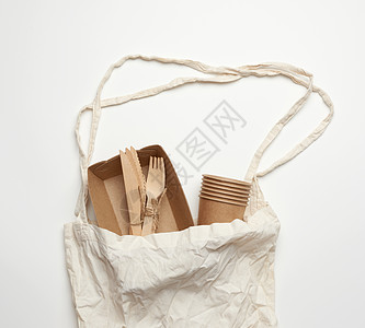 白色纺织袋和棕色手工艺板的一次性餐具工艺环境刀具材料午餐生物竹子野餐食物用具图片