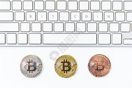 金 银和青铜比硬币 顶视角平坦金子互联网电脑桌子勋章电话商业贸易银行键盘图片