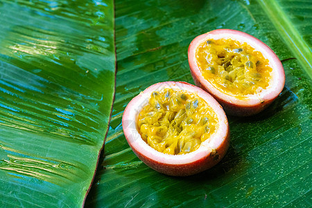 在湿香蕉叶上提取激情果实 维生素 水果 健康食品甜点叶子热带情调紫色香蕉美食果汁种子小吃图片