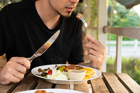 在夏日咖啡厅的餐桌上吃牛排的家伙美食商业盘子餐厅桌子食物成人营养牛扒午餐图片