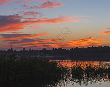 河流上美丽的橙色夕阳天空 有草图片