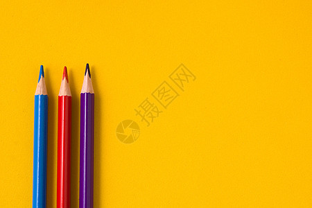 黄色背景上的彩色铅笔 复制空间学校大学紫色孩子们蓝色红色教育图片