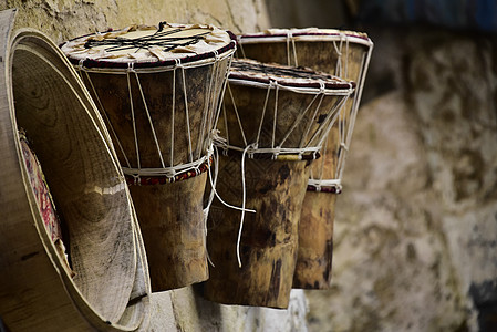 非洲鼓Djembe和鼓架挂在Cra外墙壁上皮肤文化手工艺术乐器韵律娱乐音乐木头仪器背景图片