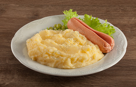 土豆泥加绿色生菜 豆子和小香肠土豆蔬菜盘子食物白色桌子木材图片