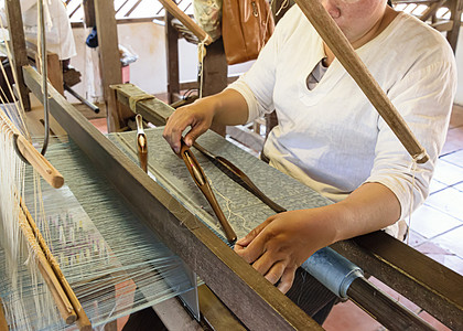 女士们在传统织布机上用丝绸手工编织古代图案女士纤维手工业织机纬线生产纺织品织物艺术机器图片