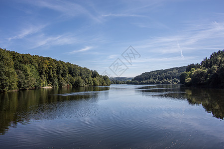 Bergisches 陆地的Lingese大坝饮用水水库棕色森林湖景绿色树木反射蓝色天空图片