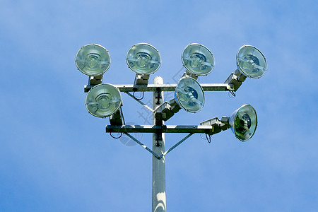 蓝色天空上的体育台泛光灯反光板邮政体育场照明技术灯柱工业玻璃金属运动图片