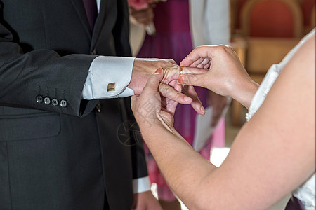 新郎和新娘交换戒指的戒指女士仪式妻子白色裙子家庭庆典婚姻手指教会图片