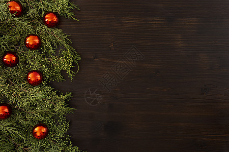 圣诞光斑平铺的圣诞节复制空间 有松树枝和红色圣诞胸围 在黑暗木头背景的一面背景