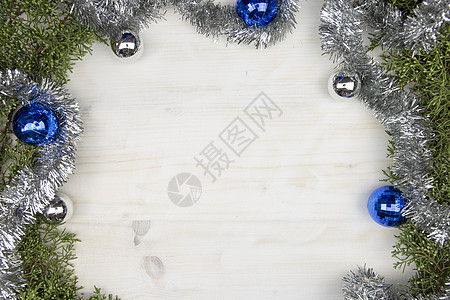 平整的圣诞节空间 有松树枝 银园 银和银以及浅木木本底的蓝圣诞面包盘图片