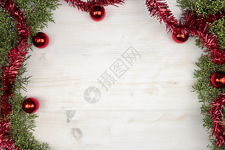 平铺圣诞复制空间 配有松树枝 红加兰和红色圣诞面包圈 以浅木木本为背景图片