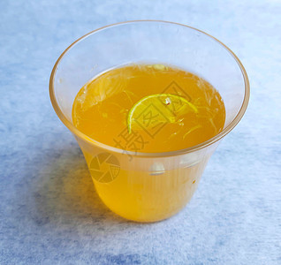 玻璃杯中的柠檬汁 在玻璃杯内外添加橙汁和柠檬片 在白色背景中精美放置图片
