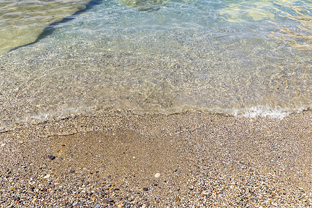 海浪在海滩上冲浪 沙滩上有黄色的沙子和清澈的水泡沫液体白色蓝色海岸波浪状阳光海洋海滨支撑图片