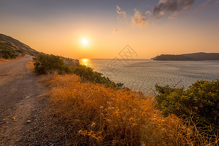 夏天在斯皮那隆加附近的克里特岛 日出岩石海岸地平线太阳旅行橙子阳光石头薄雾山脉图片