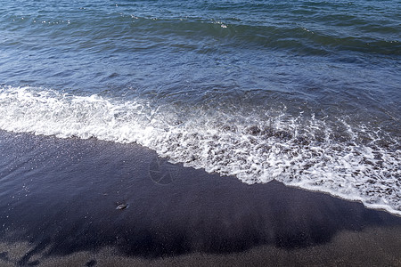 海浪在海滩上与黑色的挥发沙滩冲浪支撑海岸泡沫热带阳光海岸线液体海洋图片