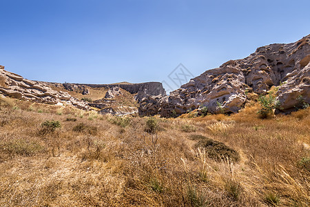 Vlychada海滩上的峡谷山脉 在一个阳光明媚的夏日太阳岩石旅游石头人行道假期黄色热带天空海岸图片