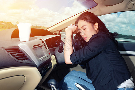 疲累的年轻女子在车里睡着车轮汽车车辆成人司机闲暇天空土地女性阳光背景图片