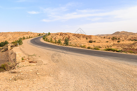 下午在撒哈拉沙漠的公路上生态峡谷场景农村爬坡旅行土地天空蓝色石头图片