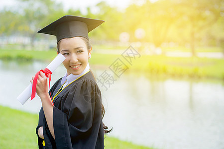 快乐的毕业学生女孩 恭喜  毕业教育员学习丝带微笑庆典仪式帽子成人成就文凭知识图片