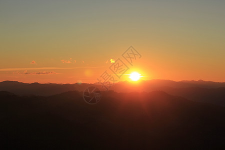 日落在山上爬坡农村顶峰旗杆阴影环境国家气候地标荒野图片