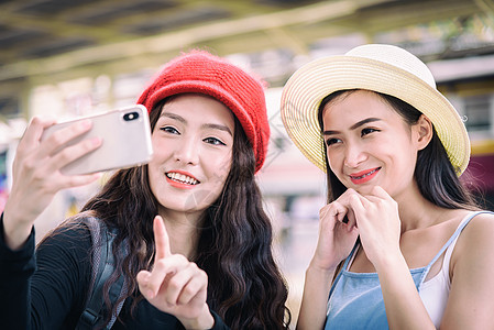 亚洲女性旅行者玩手机和聊天 并使用手机火车夫妻电话假期朋友乘客蓝色游客女孩窗户图片