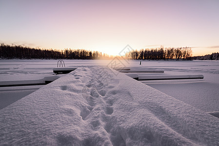 冰湖和森林已经覆盖了大雪和漂亮的薄膜天气橙子日落紫色暴风雪松树蓝色天空环境国家图片