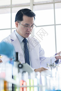 亚洲资深科学家在实验室研究和学习器皿药品蓝色生物生物学惊喜黄色男性玻璃工人图片