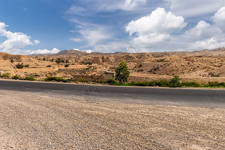 下午在撒哈拉沙漠的公路上峡谷土地石头爬坡国家场景旅行岩石危险生态图片