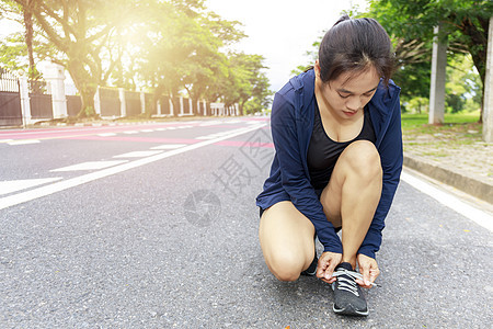 年轻女跑者绑着鞋带的丝带图片